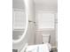 Bathroom with white fixtures, a window with blinds, and a mirror at 322 E Rhinehill Rd, Atlanta, GA 30315
