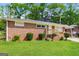 View of brick house with well-maintained lawn and manicured shrubs at the facade at 322 E Rhinehill Rd, Atlanta, GA 30315