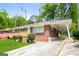 Brick house featuring a convenient carport and well-kept lawn on a sunny day at 322 E Rhinehill Rd, Atlanta, GA 30315