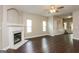 Bright living room with a fireplace, ceiling fan, hardwood floors, and access to the staircase at 7481 Absinth Dr, Atlanta, GA 30349