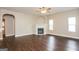 Cozy living room with a fireplace, ceiling fan, hardwood floors, and two bright windows at 7481 Absinth Dr, Atlanta, GA 30349