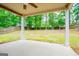 Spacious covered patio with a view of the lush, green backyard and wooded area at 1015 Buckeye Ln, Villa Rica, GA 30180