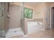 Well-lit bathroom featuring a walk-in shower and a soaking tub near a window at 1015 Buckeye Ln, Villa Rica, GA 30180