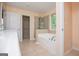 Bright bathroom featuring a soaking tub with a shower and a spacious walk-in closet at 1015 Buckeye Ln, Villa Rica, GA 30180
