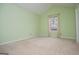 Green-painted bedroom featuring neutral carpet, trim, curtains, and a large window at 1015 Buckeye Ln, Villa Rica, GA 30180