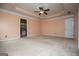 Spacious carpeted bedroom featuring tray ceiling, ceiling fan, and a doorway at 1015 Buckeye Ln, Villa Rica, GA 30180
