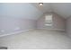 A spacious bonus room with vaulted ceilings, neutral carpet and a window for natural light at 1015 Buckeye Ln, Villa Rica, GA 30180