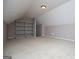 Spacious bonus room with vaulted ceilings, neutral carpet, and shelving at 1015 Buckeye Ln, Villa Rica, GA 30180