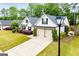 Overhead shot of charming home featuring a two-car garage, complemented by lush green landscaping and manicured bushes at 1015 Buckeye Ln, Villa Rica, GA 30180