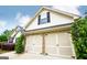 Attached two-car garage with traditional doors, stone accents, and manicured landscaping at 1015 Buckeye Ln, Villa Rica, GA 30180
