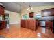 Open kitchen with cherry wood cabinetry, stainless steel appliances, and hardwood flooring at 1015 Buckeye Ln, Villa Rica, GA 30180