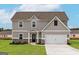 Two-story home featuring a light gray exterior, a two-car garage, and a well-manicured lawn at 240 Oliver Dr, Locust Grove, GA 30248