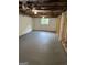 Unfinished basement with concrete floor, exposed ceiling, and natural light from window at 132 N Johnson St, Bowdon, GA 30108
