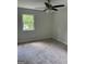 Cozy carpeted bedroom featuring a ceiling fan and natural light at 132 N Johnson St, Bowdon, GA 30108