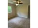 Bedroom featuring neutral carpet, ceiling fan and a window with wooded view at 132 N Johnson St, Bowdon, GA 30108