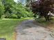 Long driveway leading to the property with lush green lawn and mature trees at 132 N Johnson St, Bowdon, GA 30108