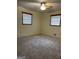 Neutral carpeted bedroom with two windows and a ceiling fan at 8672 Bowden St, Douglasville, GA 30134
