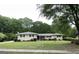 Charming ranch-style home featuring a well-manicured lawn, flowering shrubs, and brick facade at 8672 Bowden St, Douglasville, GA 30134