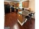 Kitchen with black appliances, hardwood floors, a breakfast bar, and wooden cabinetry at 4832 Batiste Ln, Acworth, GA 30101