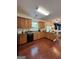 Spacious kitchen with hardwood floors, wooden cabinetry, black appliances and eat in bar area at 4832 Batiste Ln, Acworth, GA 30101