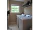 Bright laundry room featuring a washer, dryer, window, and storage at 4832 Batiste Ln, Acworth, GA 30101