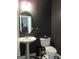 Modern powder room featuring pedestal sink, decorative mirror and patterned floors at 4832 Batiste Ln, Acworth, GA 30101