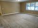 Spacious bedroom showcasing neutral carpet, paint, and natural light from a large window at 8660 Bowden St, Douglasville, GA 30134