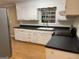 Kitchen featuring black countertops, stainless steel appliances, and hardwood floors at 8660 Bowden St, Douglasville, GA 30134