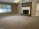 Bright living room featuring a brick fireplace, neutral carpet, and lots of natural light at 8660 Bowden St, Douglasville, GA 30134
