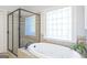 Luxurious bathroom features a large soaking tub, a separate shower, and decorative tile accents at 8710 Gilmer Ft, Cumming, GA 30028
