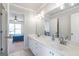 Elegant bathroom featuring double sinks and a vanity with views into a bedroom at 8710 Gilmer Ft, Cumming, GA 30028