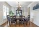 Elegant dining room with a dark wood table, chandelier, and wainscoting at 8710 Gilmer Ft, Cumming, GA 30028