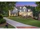 Beautiful two-story home with a well-manicured lawn and inviting front porch at dusk at 8710 Gilmer Ft, Cumming, GA 30028