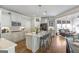 Open kitchen with island, white cabinets, granite countertops, and modern appliances at 8710 Gilmer Ft, Cumming, GA 30028