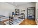 Well-lit home office featuring a modern desk, shelving units, and hardwood floors at 8710 Gilmer Ft, Cumming, GA 30028