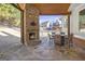 Covered outdoor patio with stone fireplace, stone floor, and outdoor dining set at 8710 Gilmer Ft, Cumming, GA 30028