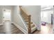 Carpeted staircase with wood railing leads to an open basement area with tile flooring at 8710 Gilmer Ft, Cumming, GA 30028