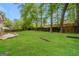 Large backyard with lush green grass, mature trees, and a wooden privacy fence at 543 Tahoe Cir, Stone Mountain, GA 30083