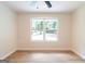 A bright, empty bedroom with a ceiling fan and light wood-look flooring overlooking a backyard at 6532 Voyles Dr, Riverdale, GA 30274