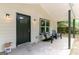 Relaxing covered front porch area with Adirondack chairs and outdoor lighting at 6532 Voyles Dr, Riverdale, GA 30274