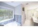 Bathroom features a soaking tub, dual sinks, white tile flooring, and a separate shower area at 95 Blue Grass Ct, Oxford, GA 30054
