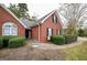 Side view showing the brick facade and manicured landscaping of this lovely home at 95 Blue Grass Ct, Oxford, GA 30054