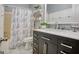 Nicely tiled bathroom featuring a single sink vanity and shower with gray and white decorative curtain at 1017 Preserve Park Dr, Loganville, GA 30052