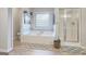 Bright bathroom featuring soaking tub, a window, and separate shower stall at 1017 Preserve Park Dr, Loganville, GA 30052