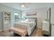This bedroom features hardwood floors, a ceiling fan, a gray upholstered bed and an upholstered bench at 1017 Preserve Park Dr, Loganville, GA 30052