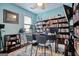 Bright office space with blue walls, a ceiling fan, and shelves filled with books and streaming equipment at 1017 Preserve Park Dr, Loganville, GA 30052