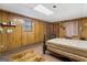 Bedroom featuring wood paneling, a neutral rug, and a decorative headboard at 693 Trailwood Dr, Riverdale, GA 30274