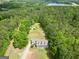 Aerial view displays house with long drive and lush green forest and lake nearby at 138 Sam Solomon Rd, Locust Grove, GA 30248
