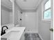 Updated bathroom featuring white cabinets, modern fixtures, and a tiled shower and decorative floor at 138 Sam Solomon Rd, Locust Grove, GA 30248