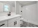 Updated bathroom with white cabinets, modern fixtures, and a tiled shower and floor at 138 Sam Solomon Rd, Locust Grove, GA 30248
